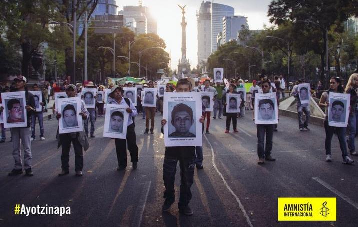 Manifestación. Se muestran personas con pancartas con las fotografías de los desparecidos en Ayotzipa