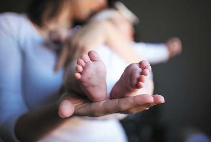 Madre sosteniendo los pies de su bebé