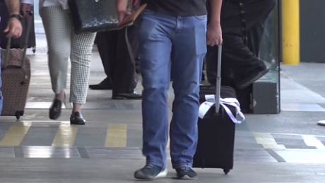 Cuatro personas caminando con valijas