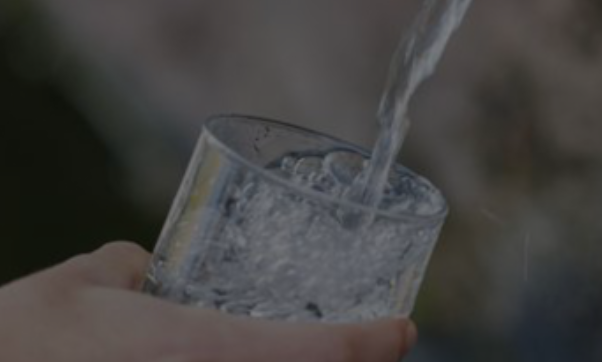 Persona llenando un vaso de agua