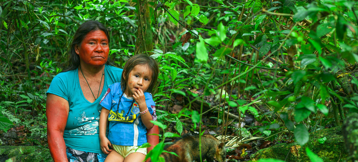 Indigena Peruana alzando a ni&ntilde;o
