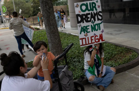 Familia Protestando con un cartel, el cual dice "Nuestros sue&ntilde;os no son ilegales".