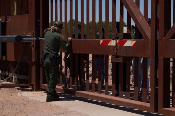 Personas haciendo fila en frontera entre M&eacute;xico y Estados Unidos.